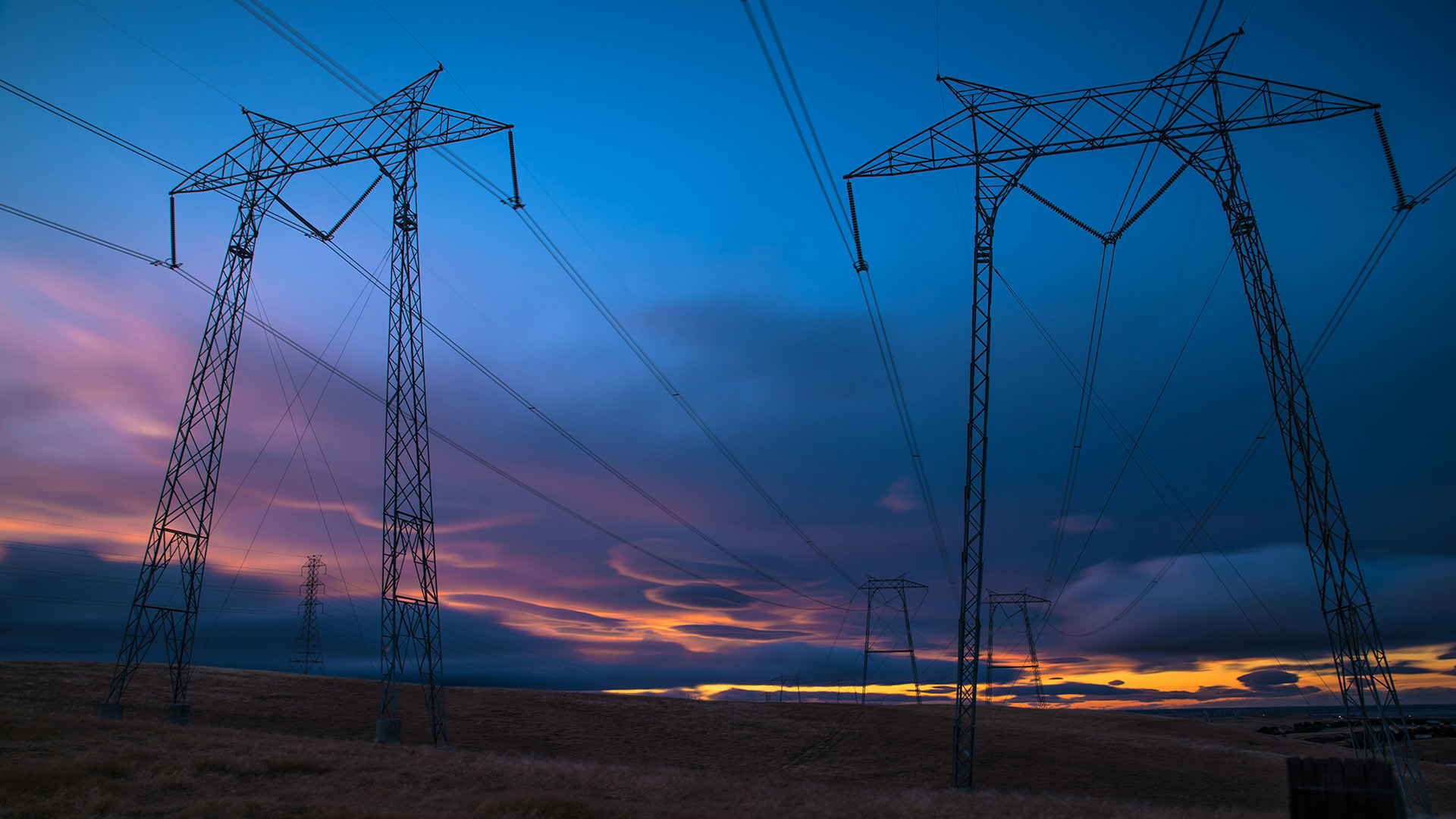 Power lines with a sunset in the background