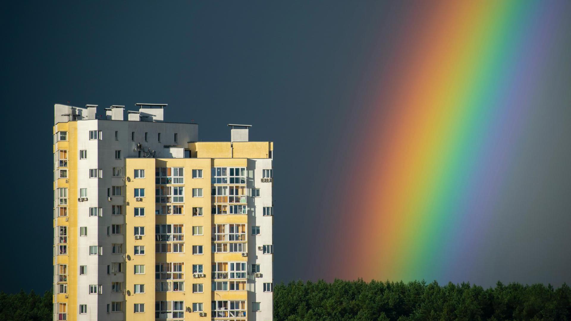 Building with rainbow in sky in the distance