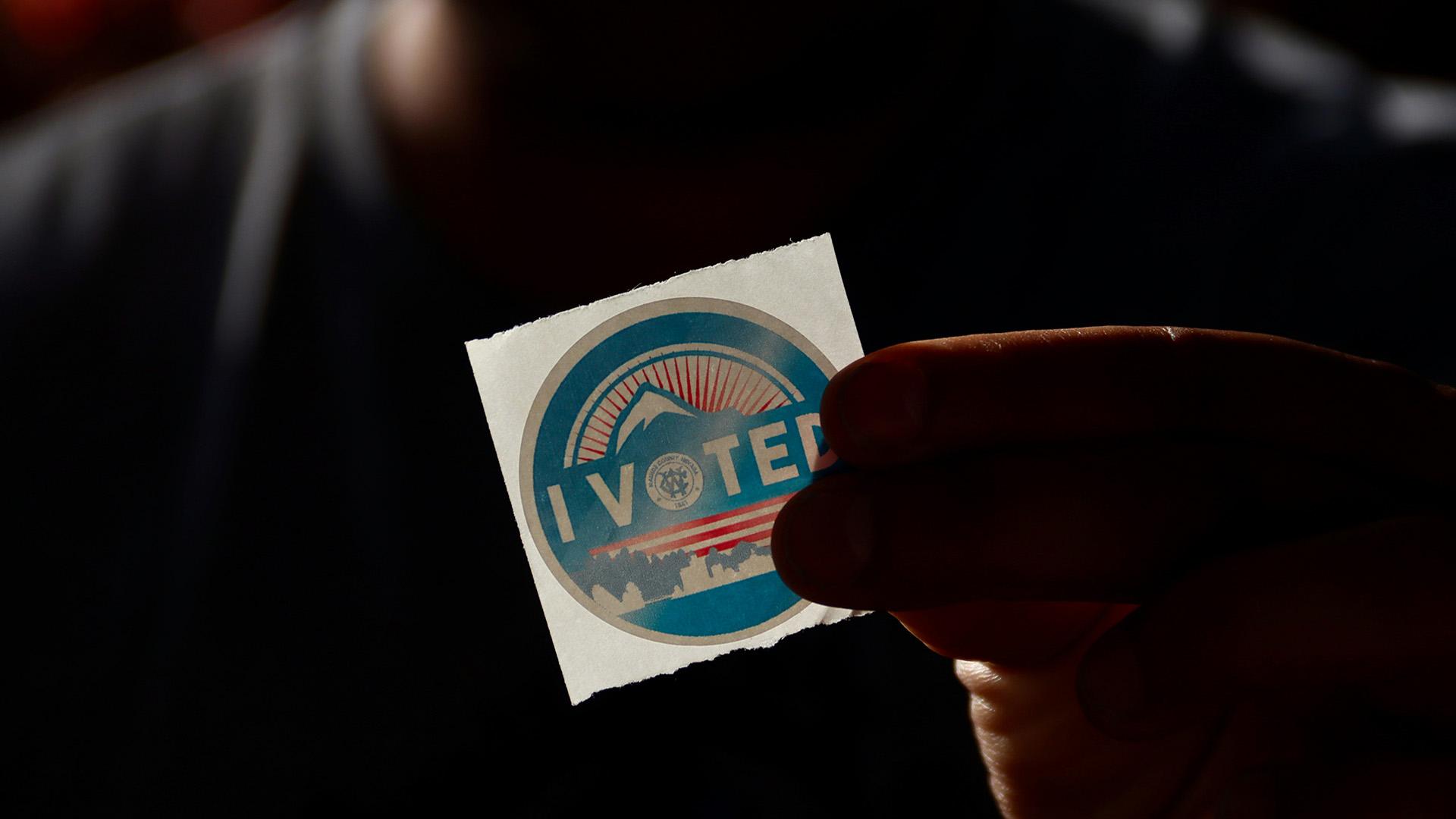 A person holding an 'I Voted' sticker