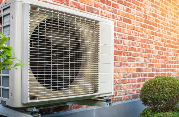 heat pump mounted on the exterior of a brick residence